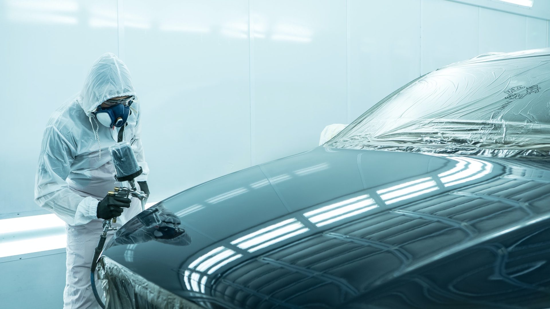 a-man-in-overalls-is-about-to-paint-a-car-1-1-e1635736280137